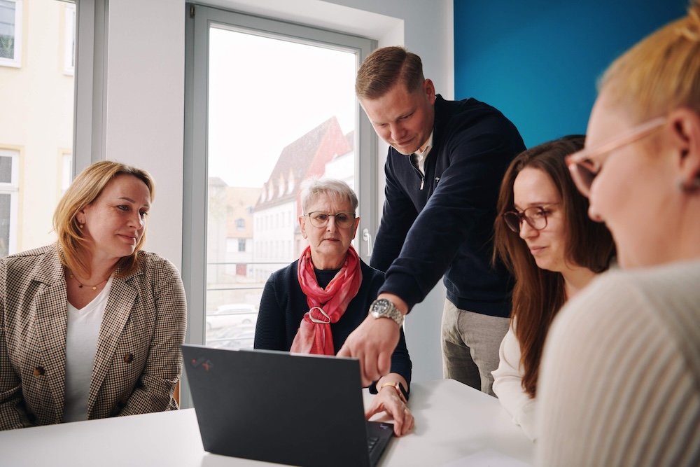Eine Gruppe von Menschen, die auf dem Laptop schauen