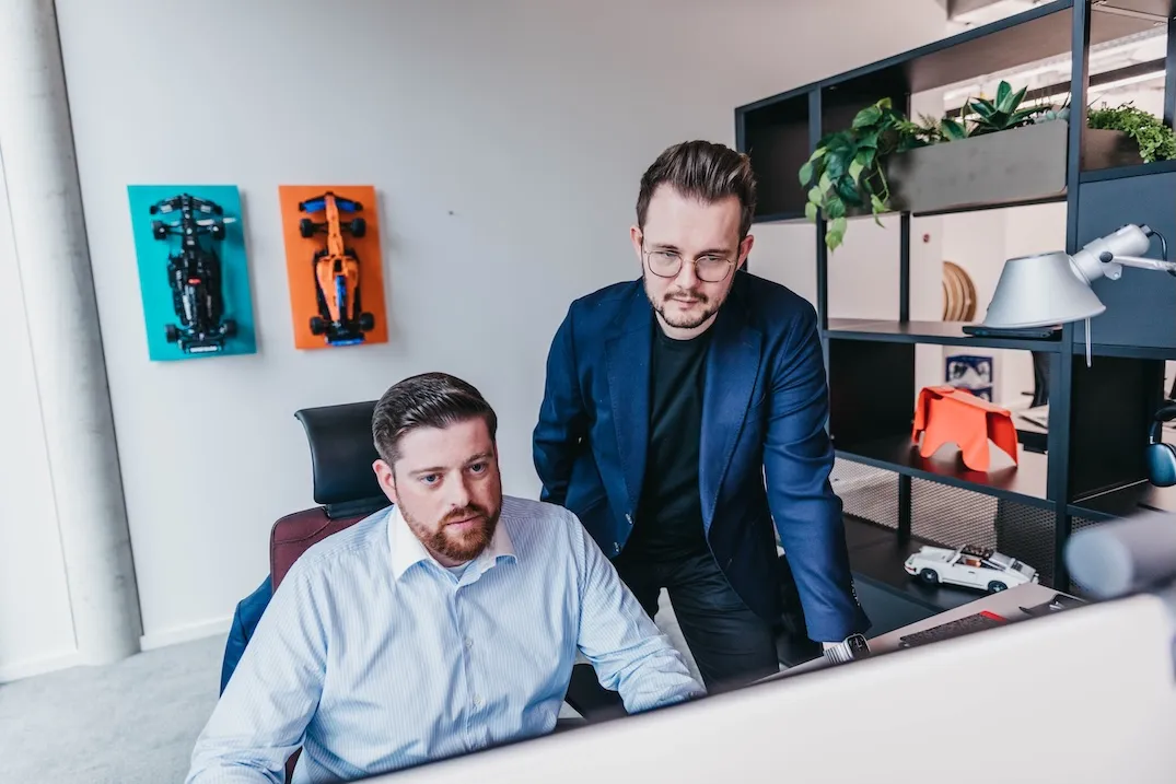 Two middle aged males looking at a computer screen