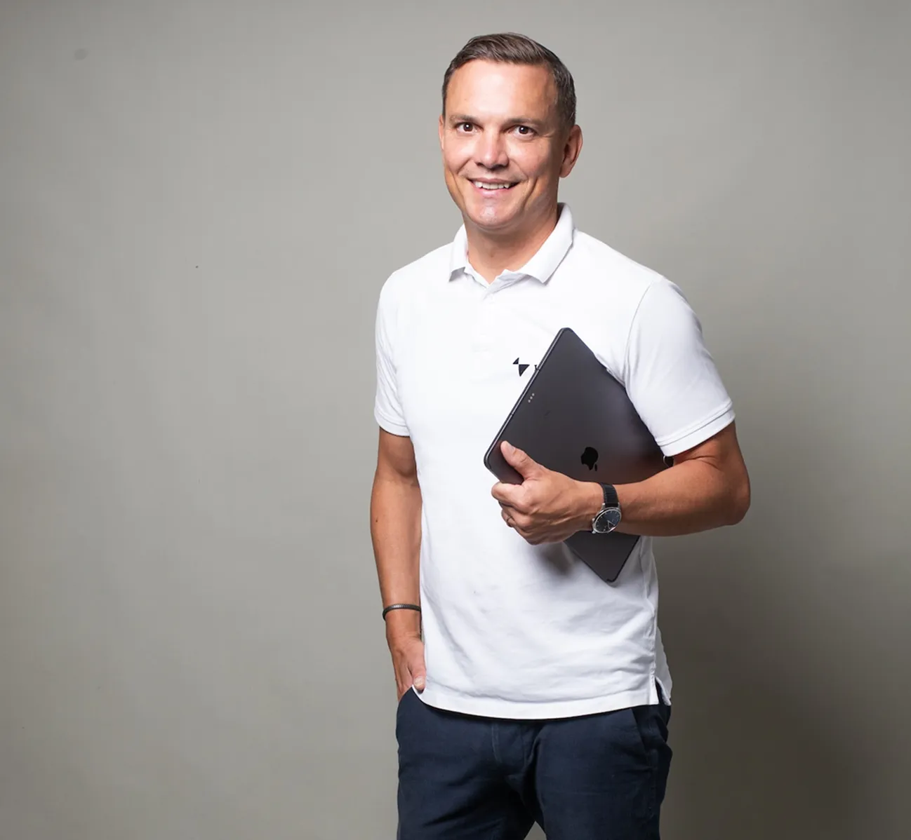 Thomas Klews, CEO von Impower lächelnd mit einem Laptop in der Hand