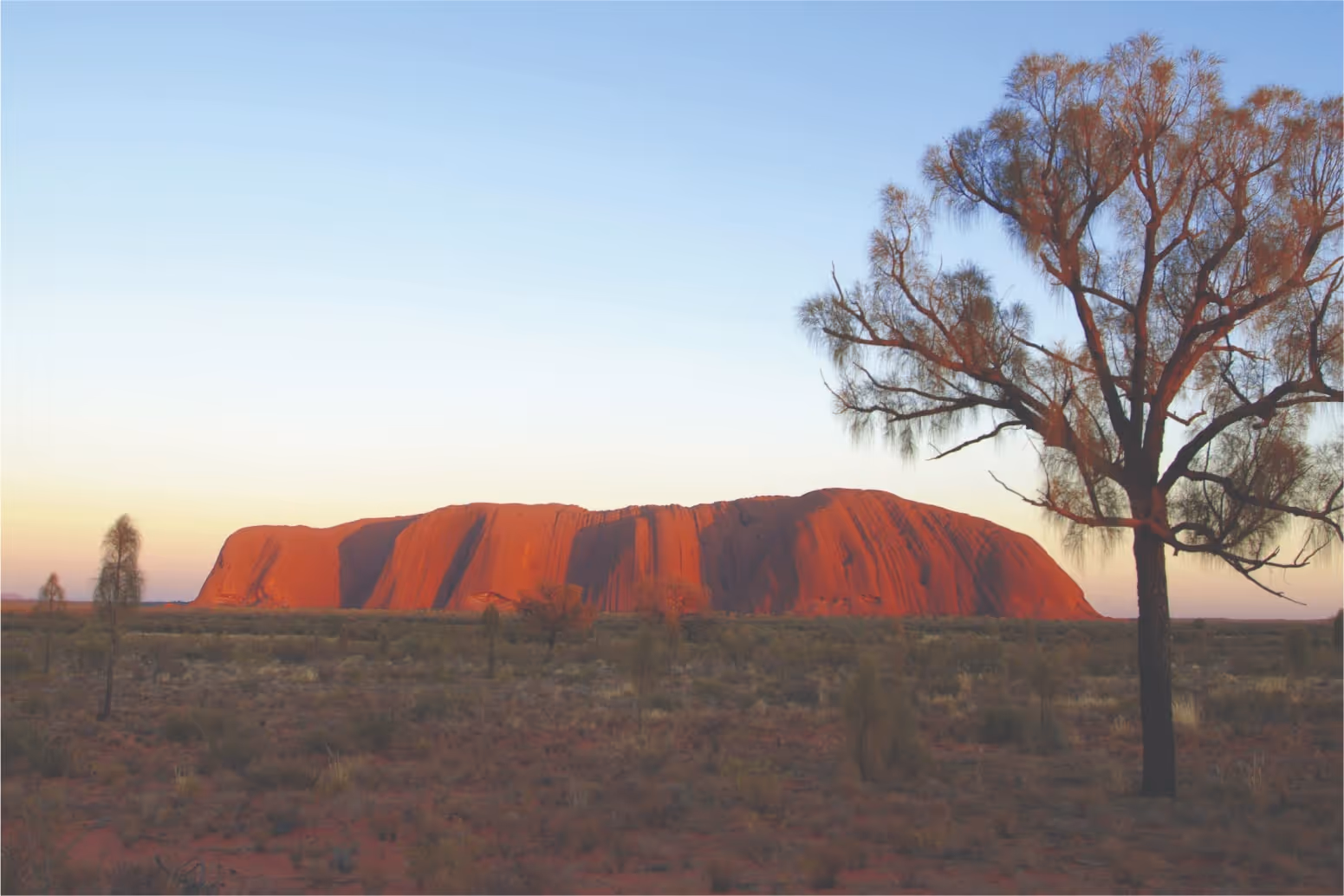 A sunset with Uluru on the horizon