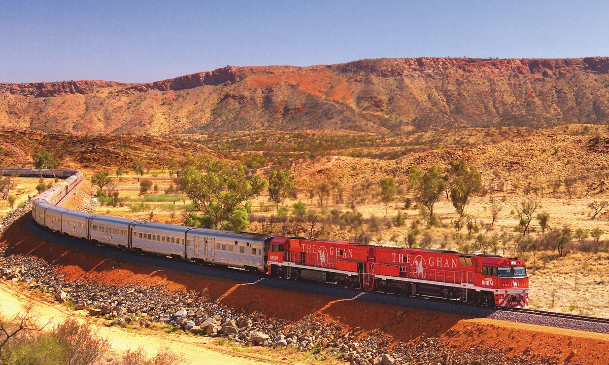 The Ghan train travelling through the red desert landscape of central Australia near Alice Springs.