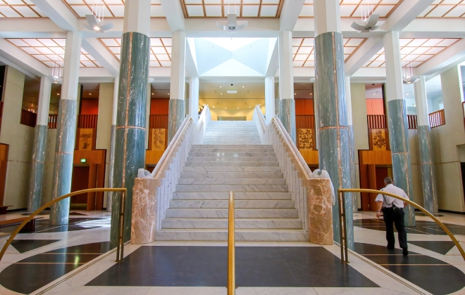 Interior hallway of Australian Parliament House featuring marble columns and polished stone flooring