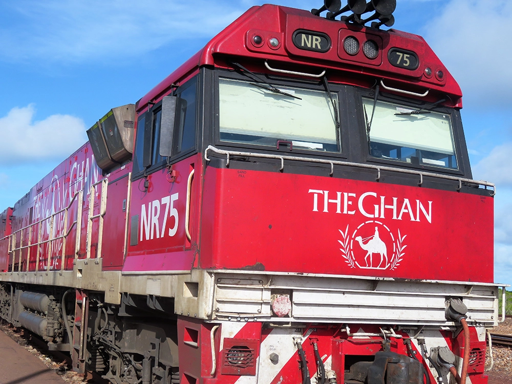 Close-up of The Ghan red locomotive (NR75) at a station in the Australian outback.
