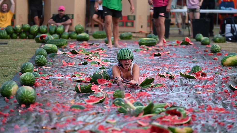 Person sliding through smashed watermelons during the Chinchilla Melon Festival in Queensland.