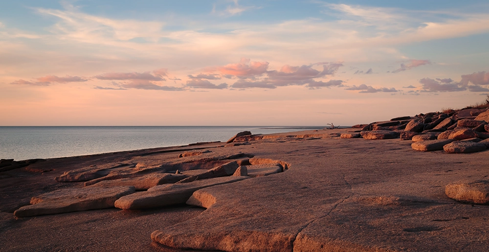 Rocky shoreline and coastal landscape at sunset in Karumba, Queensland.