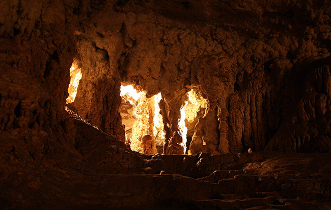 Sunlight illuminating rugged limestone formations inside Naracoorte Caves, South Australia.