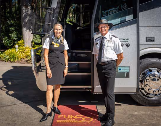 Fun Over 50 Holidays tour host and driver standing at the open door of a Diamond Class coach