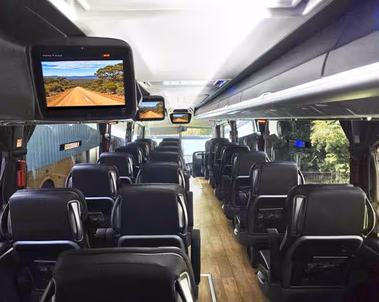 Interior of a Diamond Class coach showing overhead monitors displaying scenic content