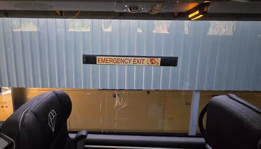 Coach side window marked with an Emergency Exit sign