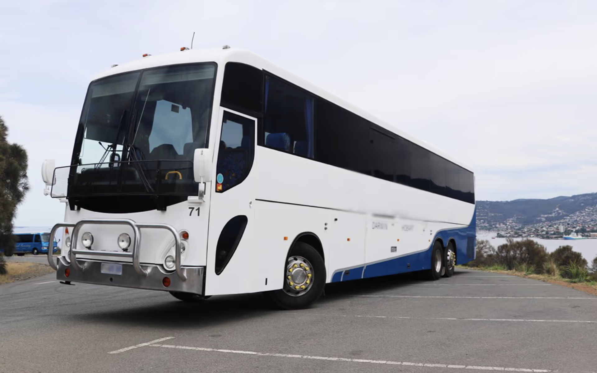 Third-party tour coach used on some itineraries, parked at a scenic coastal location