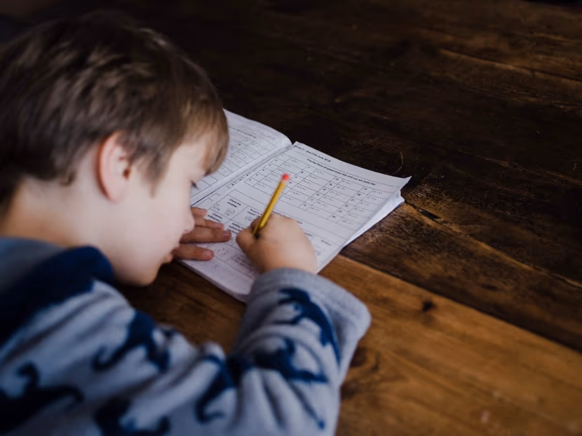 A young boy completing his math homework
