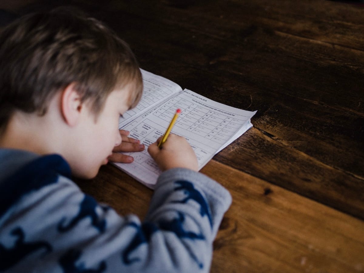 A young boy completing his math homework