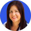 Smiling woman with long dark hair against a blue circular background.