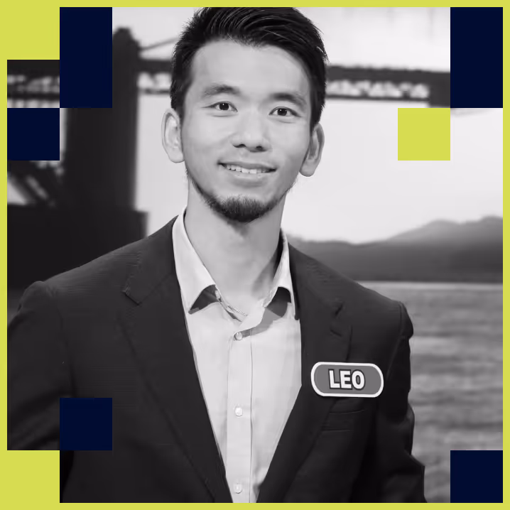 Smiling man wearing a suit jacket with a name tag labeled 'LEO' and a blurred bridge in the background.