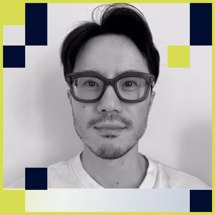 Black and white portrait of a man with short hair, glasses, and light facial hair, wearing a white shirt.
