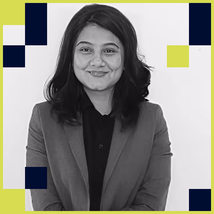 Portrait of a smiling woman with shoulder-length hair wearing a blazer over a dark shirt against a white background with decorative blue and lime green squares.