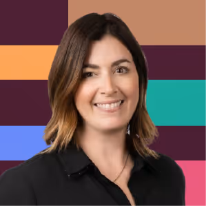 Smiling woman with shoulder-length brown hair wearing a black top against a colorful striped background.