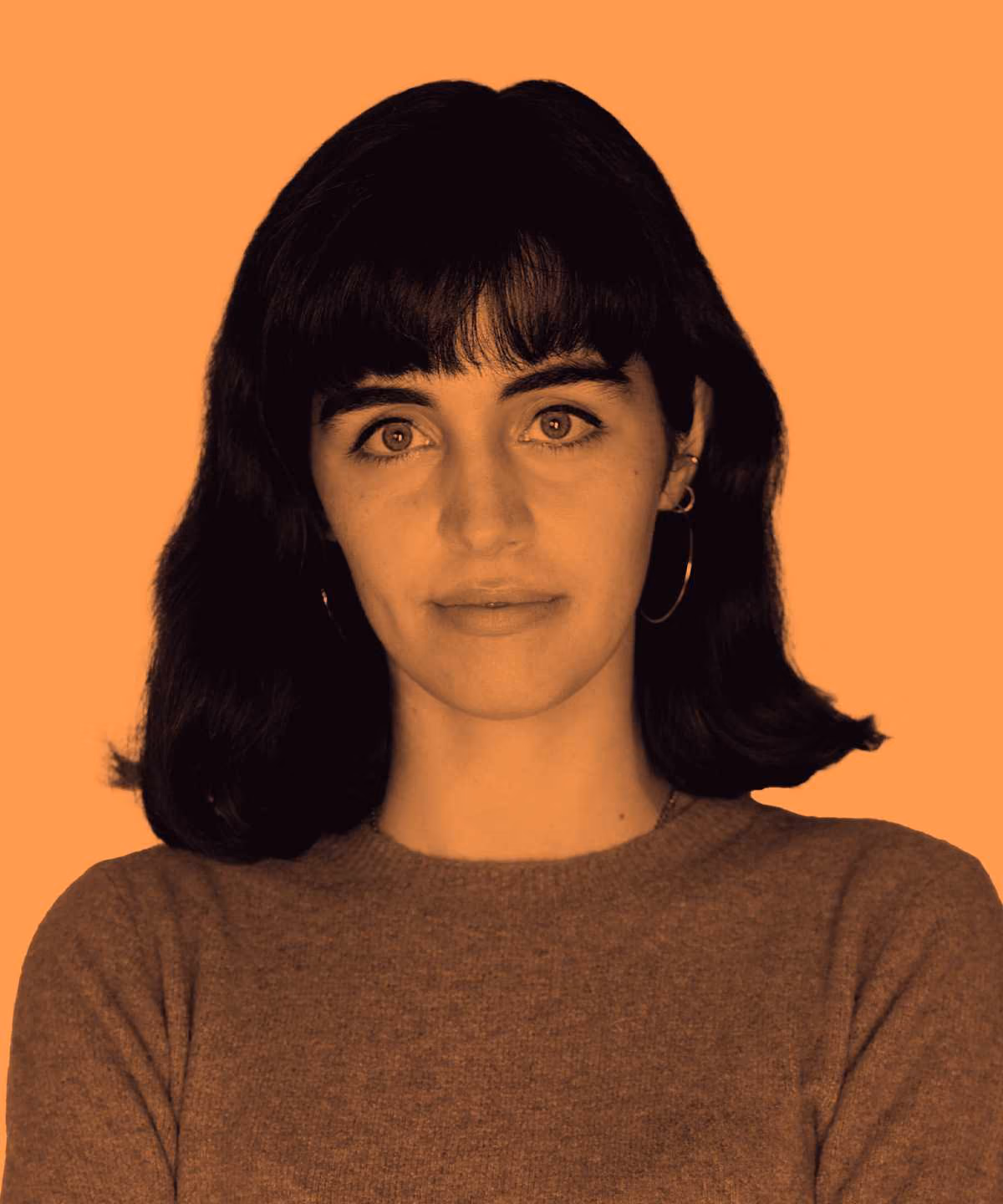 Portrait of a woman with shoulder-length dark hair and bangs against an orange background.