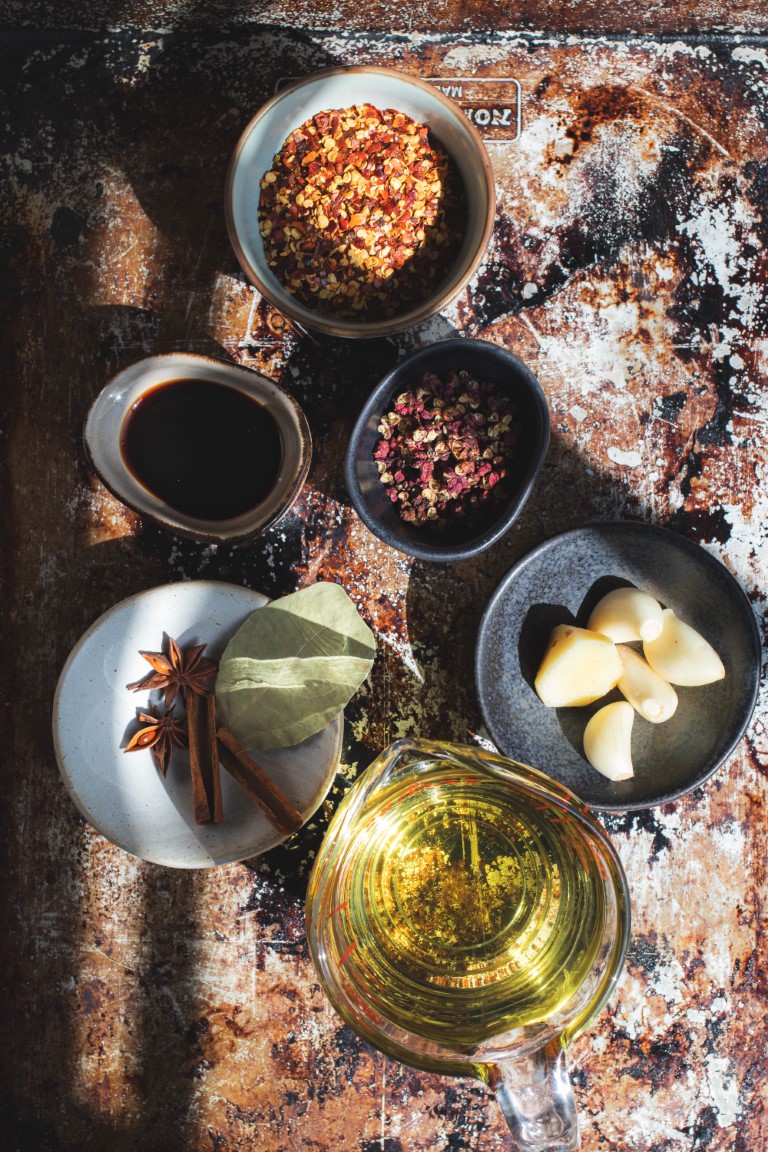 Tray of ingredients for making Sichuan chili oil including red chili flakes and Sichuan peppercorns