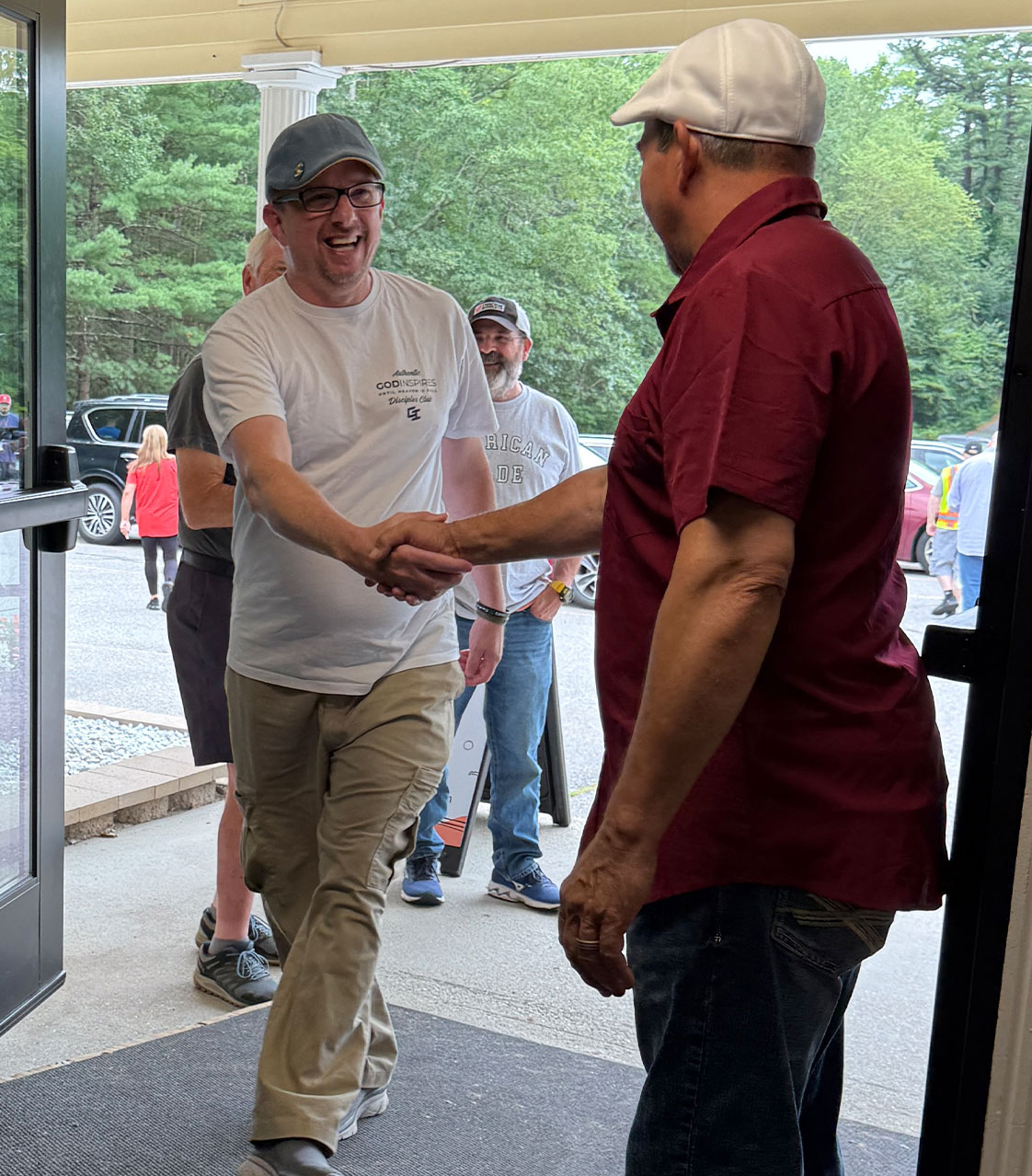 Greeter shaking hands with a smiling guest at the front doors of Granite United Church