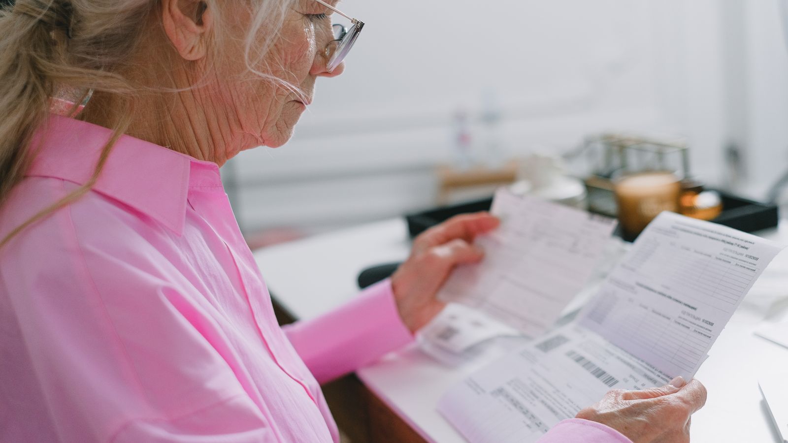 A woman at home reading through her household paperwork