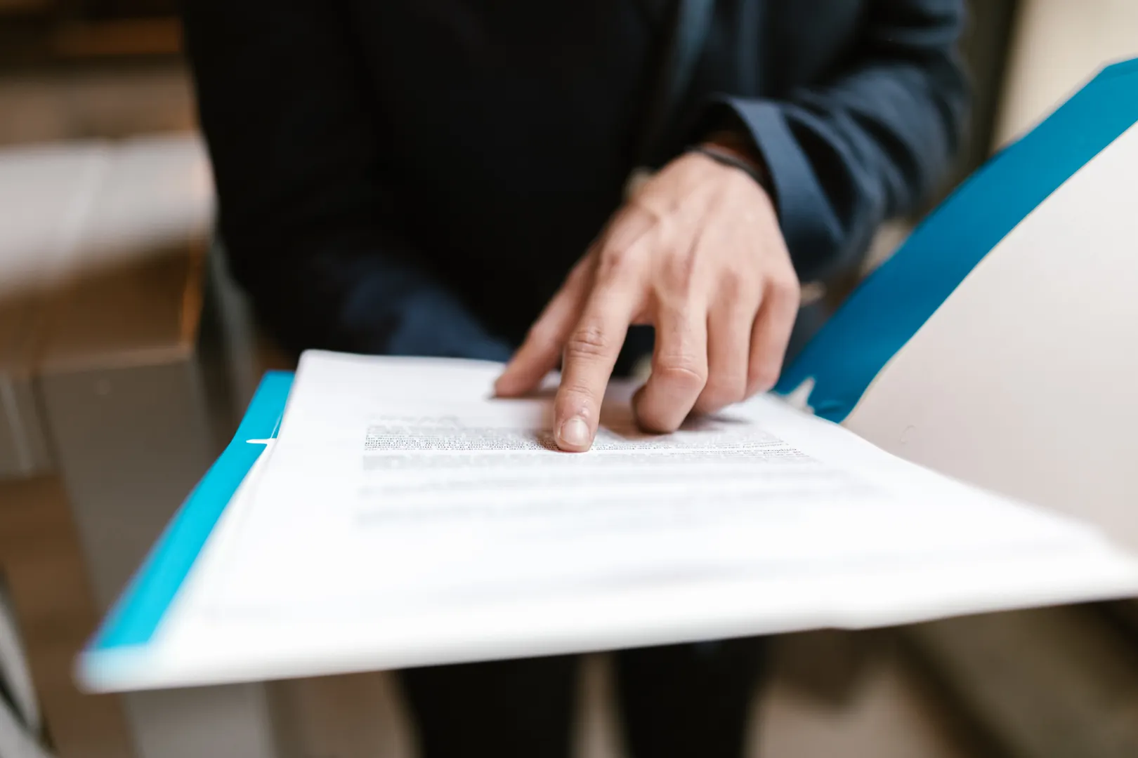 A hand traces the small print in a document