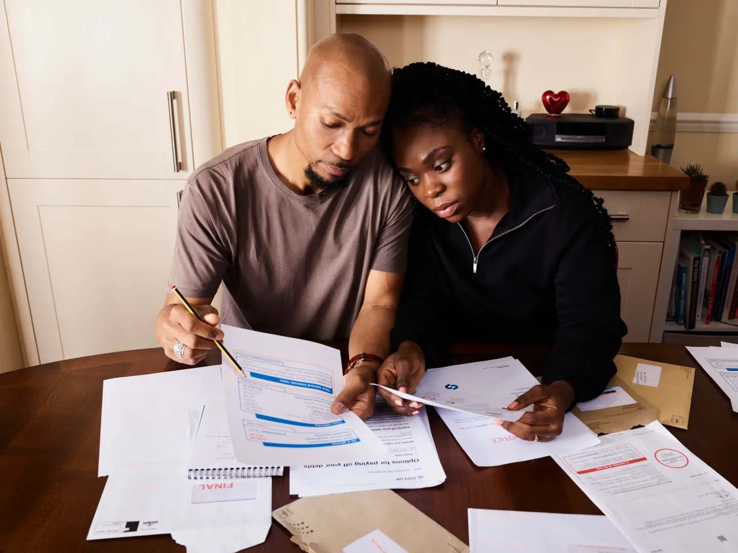 A couple reviewing household documents together at a kitchen table