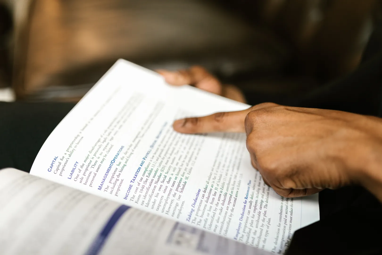A hand pointing to terms on a printed page