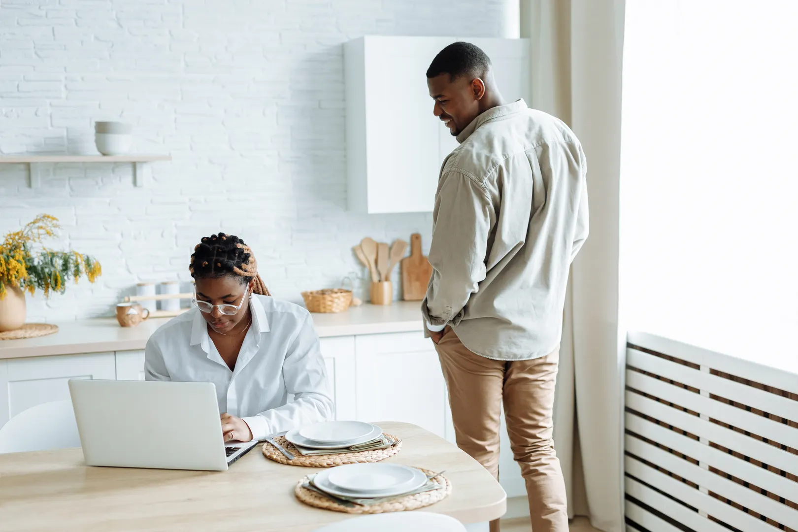Couple reviewing a laptop together at a kitchen table