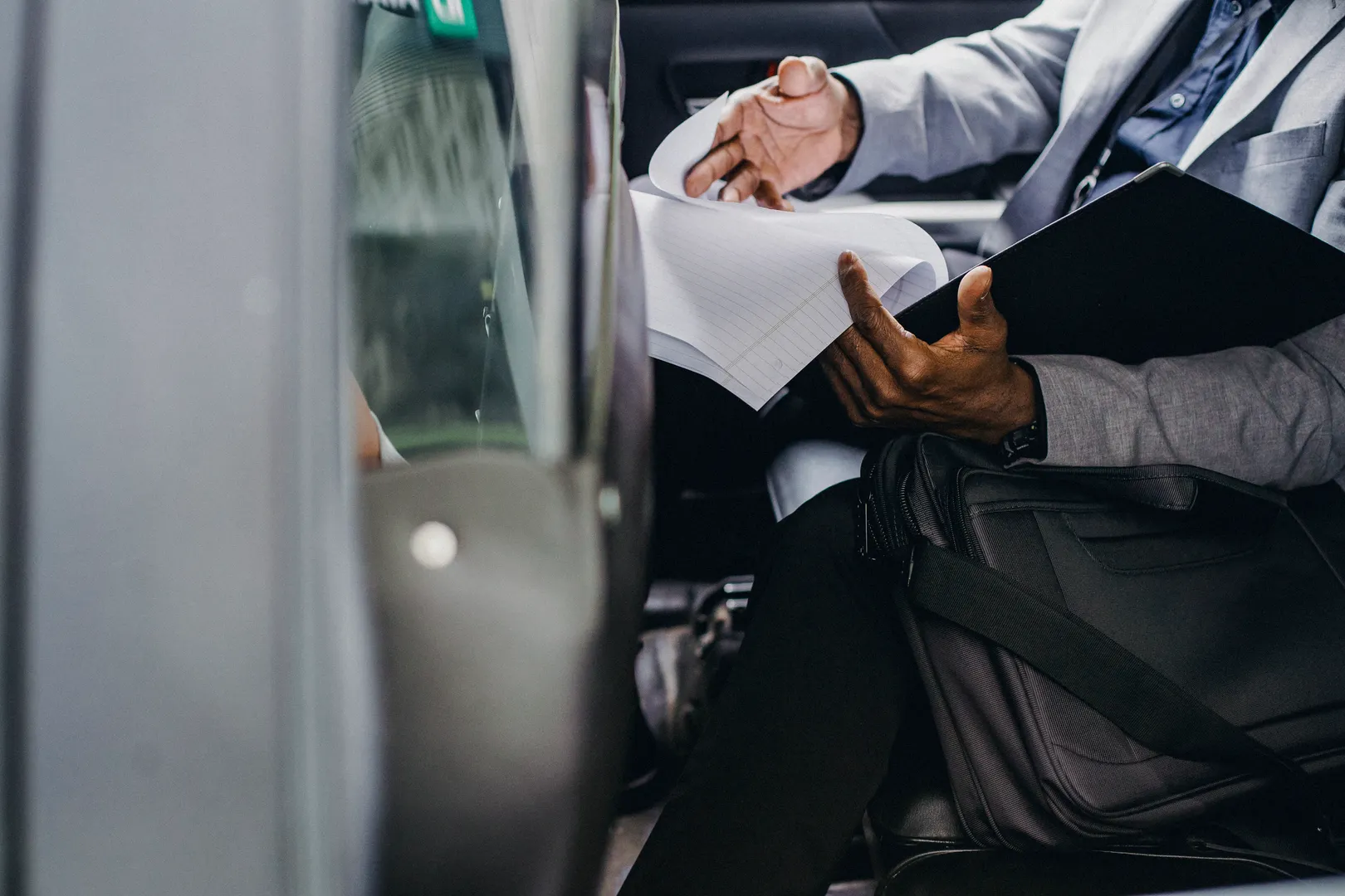 Person reviewing paperwork while seated inside a vehicle