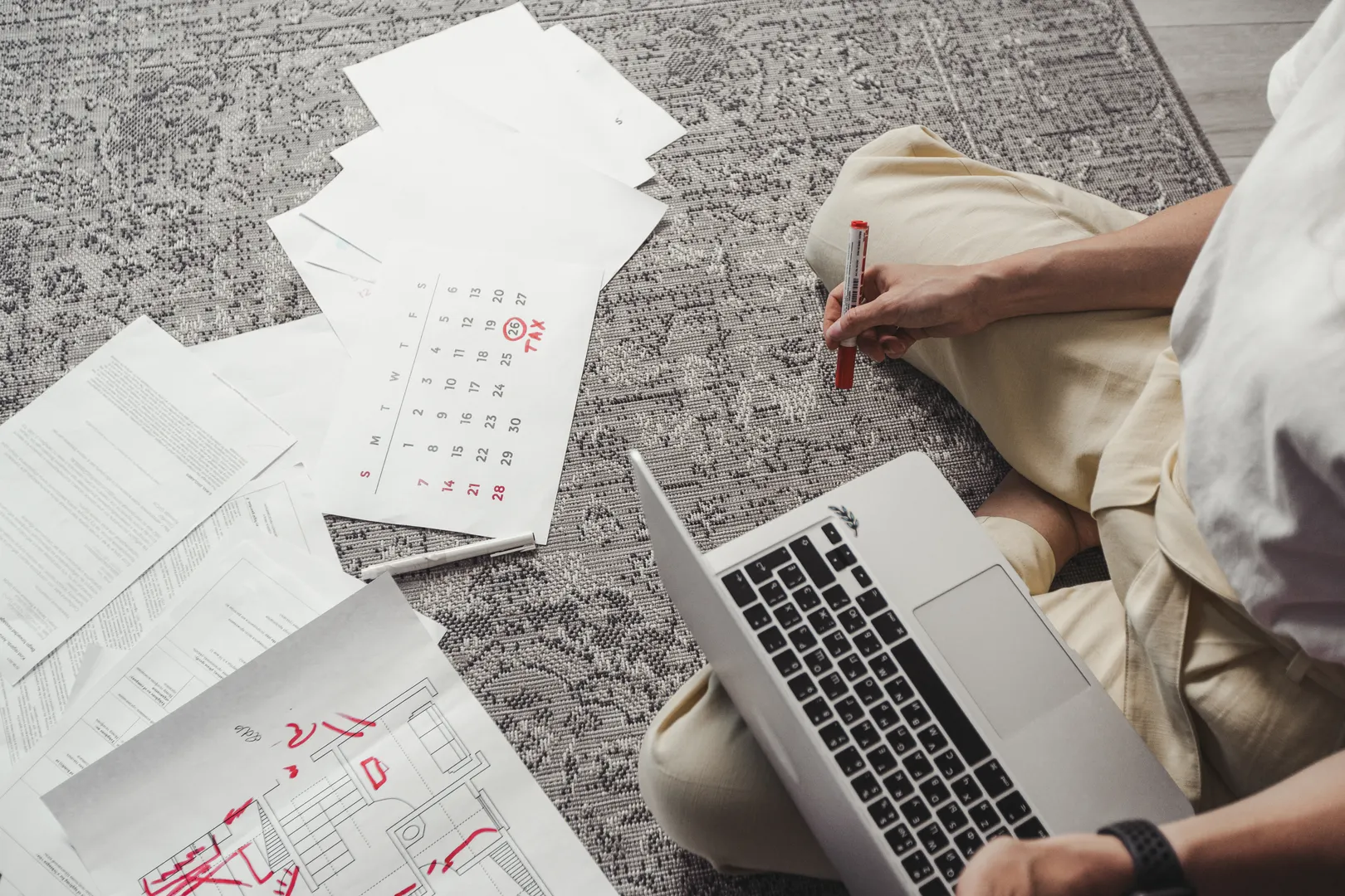 Person planning dates among receipts and a laptop