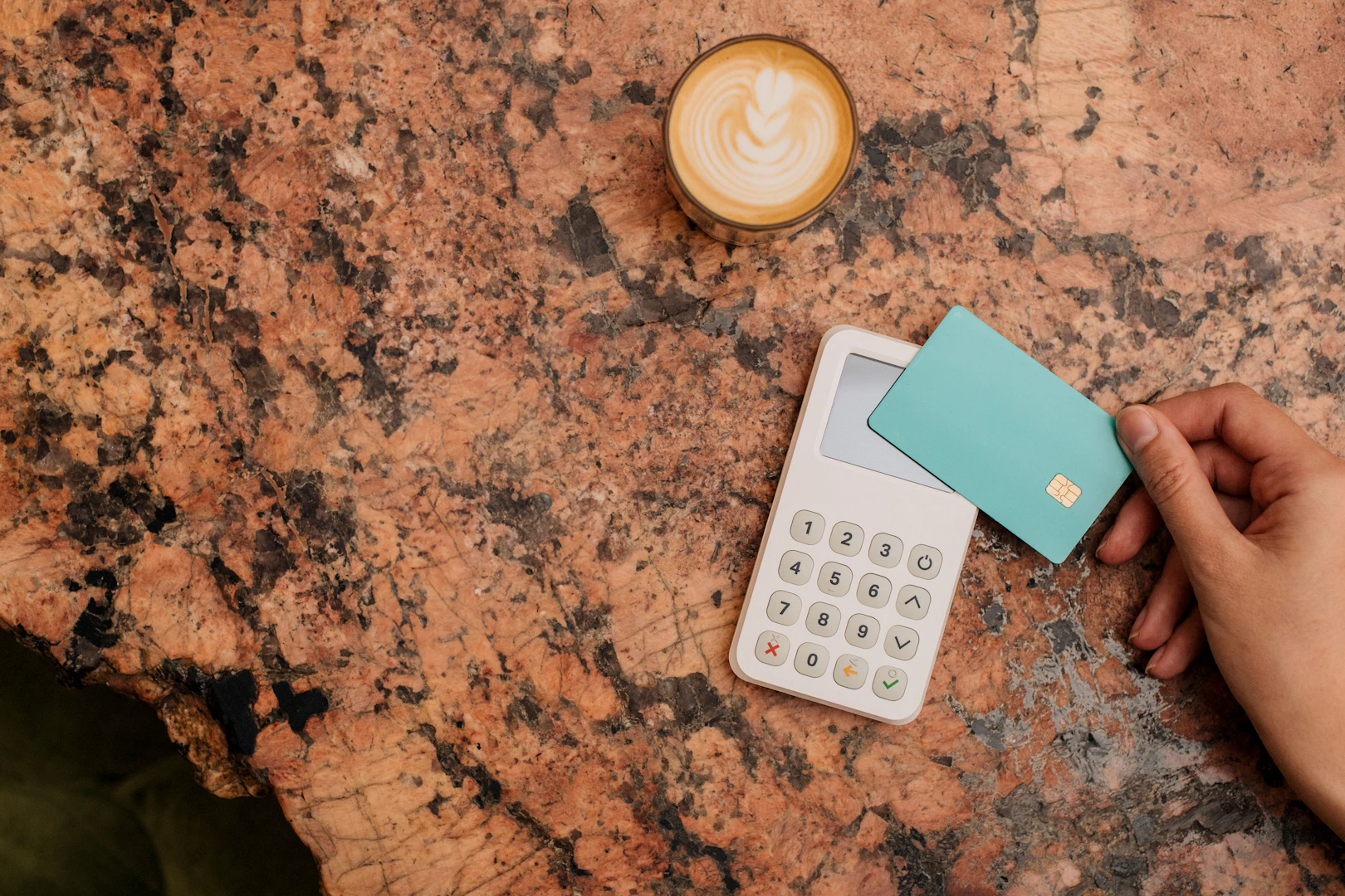 Hand holding a plain card above a calculator