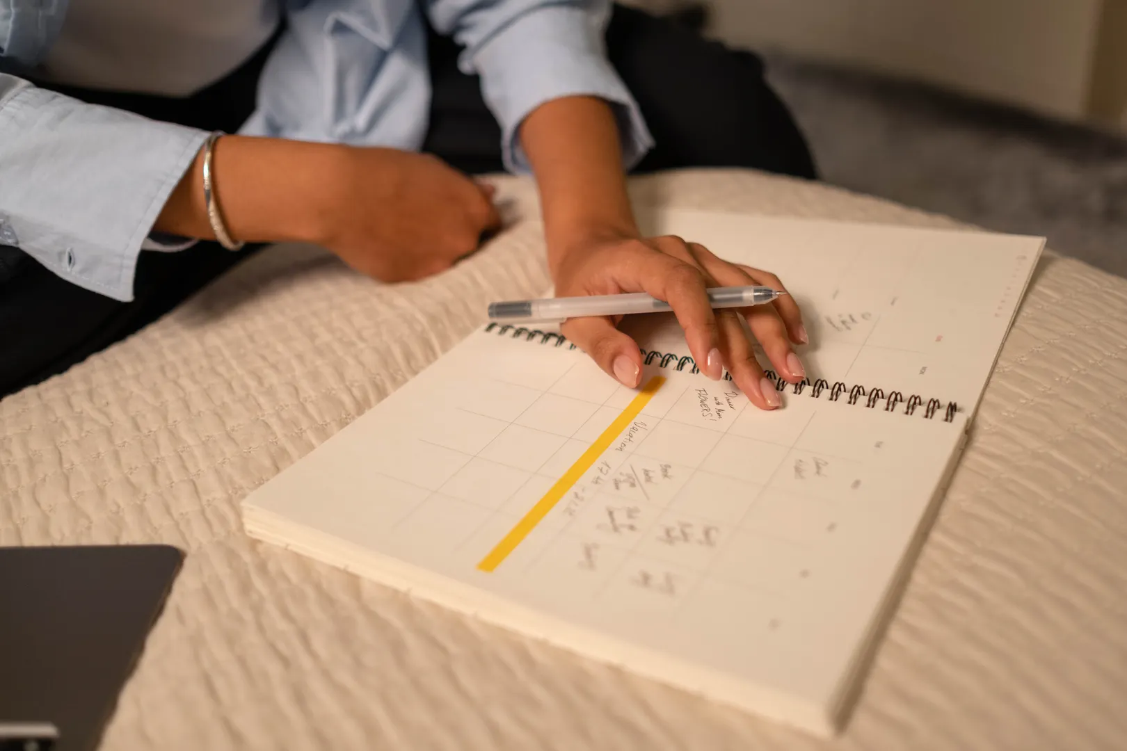 Hands marking dates in a large spiral calendar