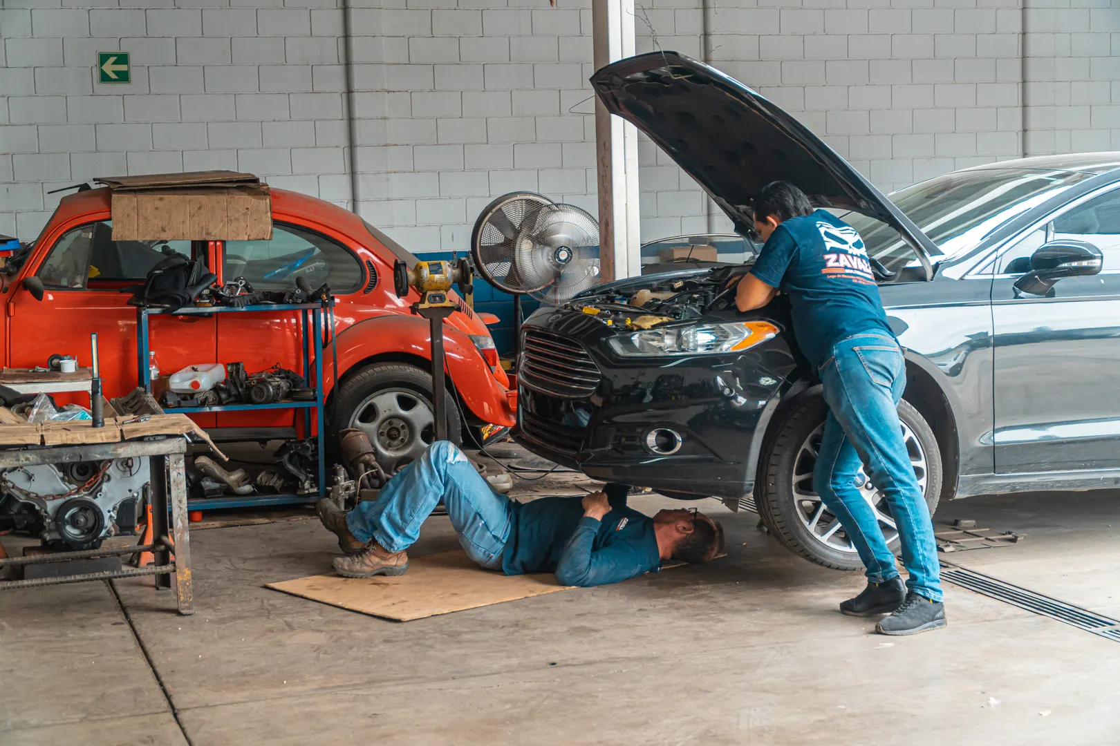 Mechanics working on cars in a repair workshop