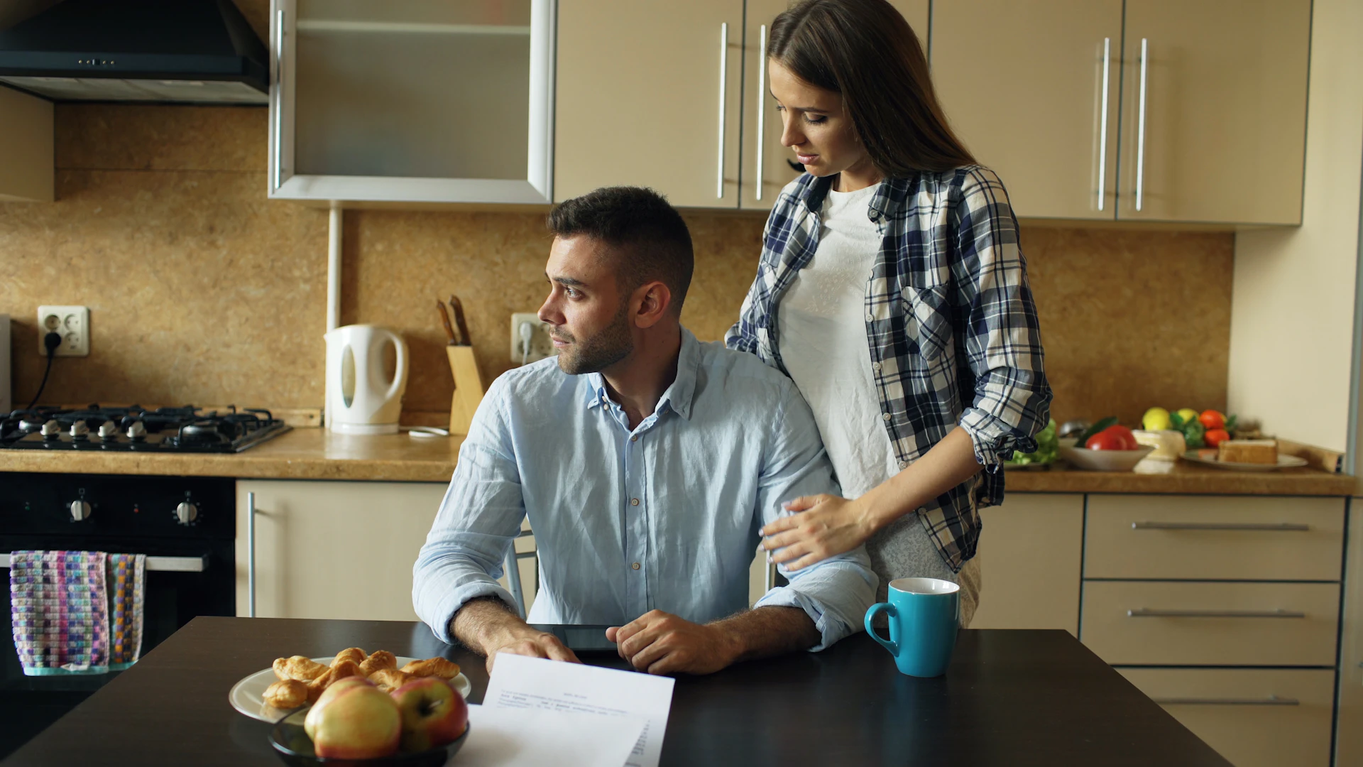 A couple at their kitchen table going through bills and statements together