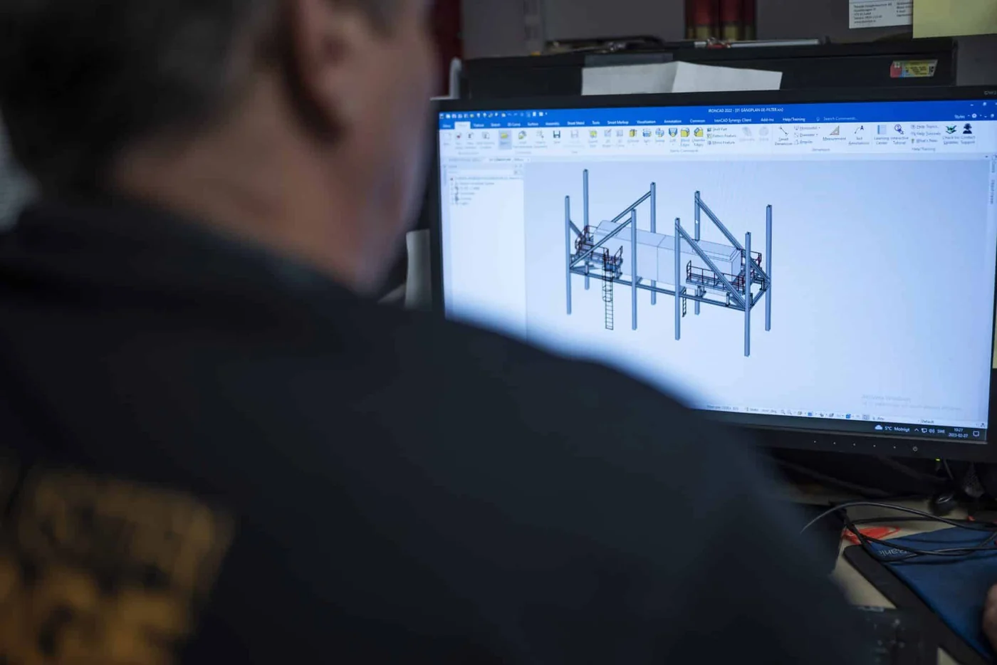 Konstruktör hos LN Industrimontage framför IRONCAD med ett entresolplan i stålprofiler med trappa och räcken på skärmen