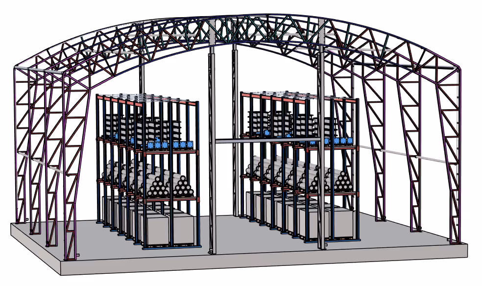 Warehouse built at IRONCAD: arched steel truss frame with pallet racks filled with pipes, boxes, and pallets on the concrete slab