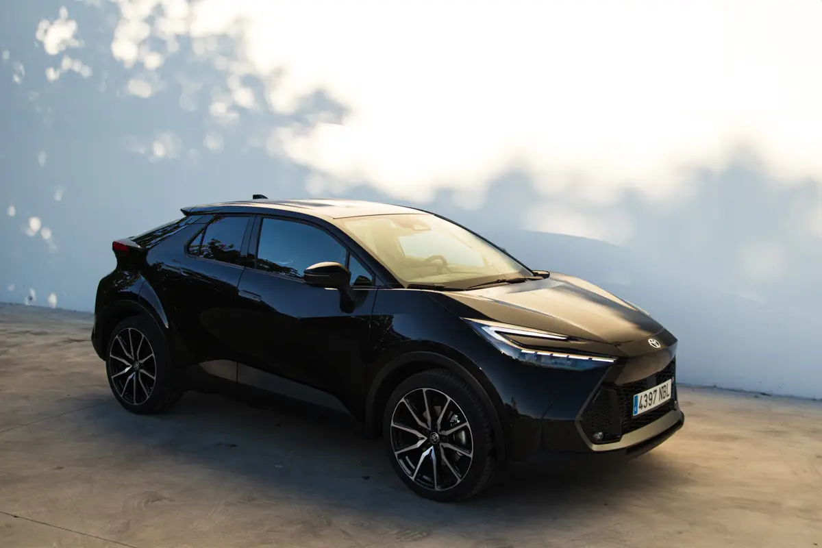Plano frontal del Toyota CHR Black Edition aparcado en ciudad con fondo urbano moderno.