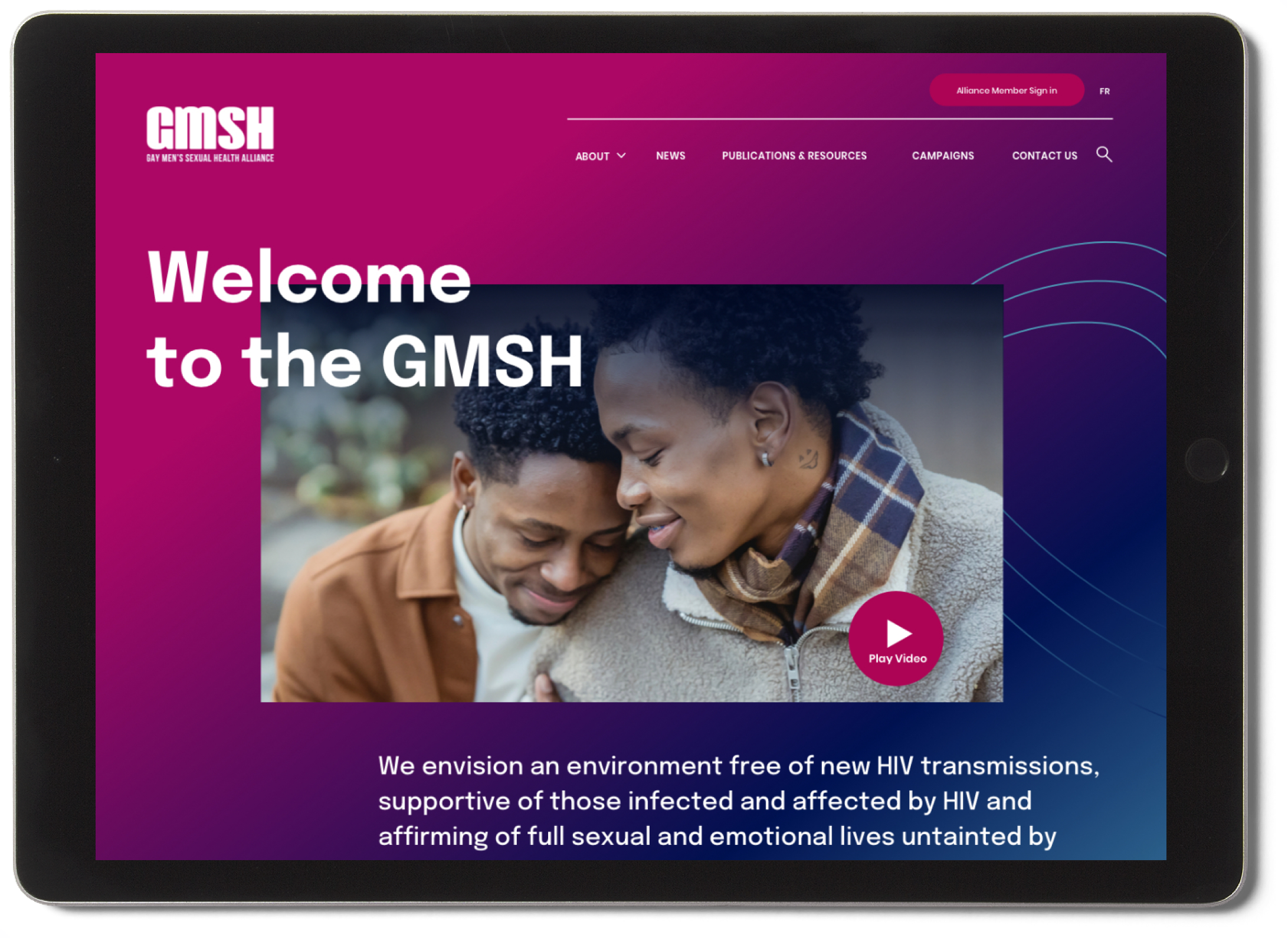 Ipad with a sneak peek of the GMSH hub home page. It is bright pink, with a visual of a happy couple and a "welcome to the GMSH caption"