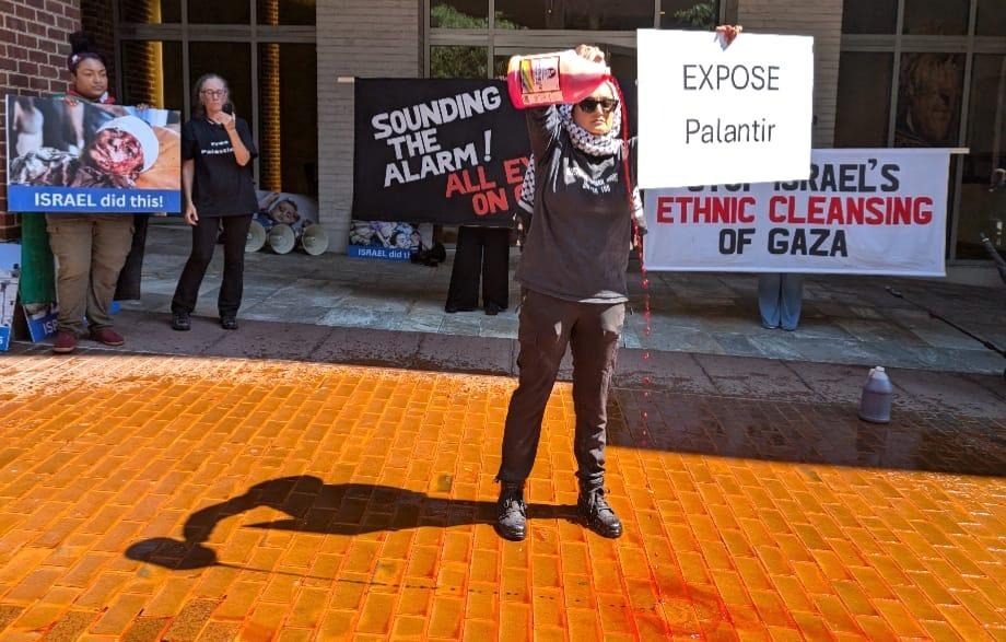 Activist dumping "fake blood" in front of Palantir offices.