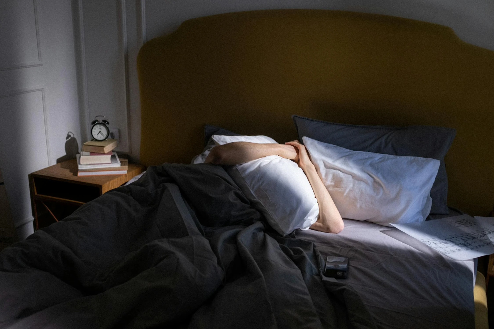 A person peacefully sleeping in a bed, resting their head on a soft pillow.