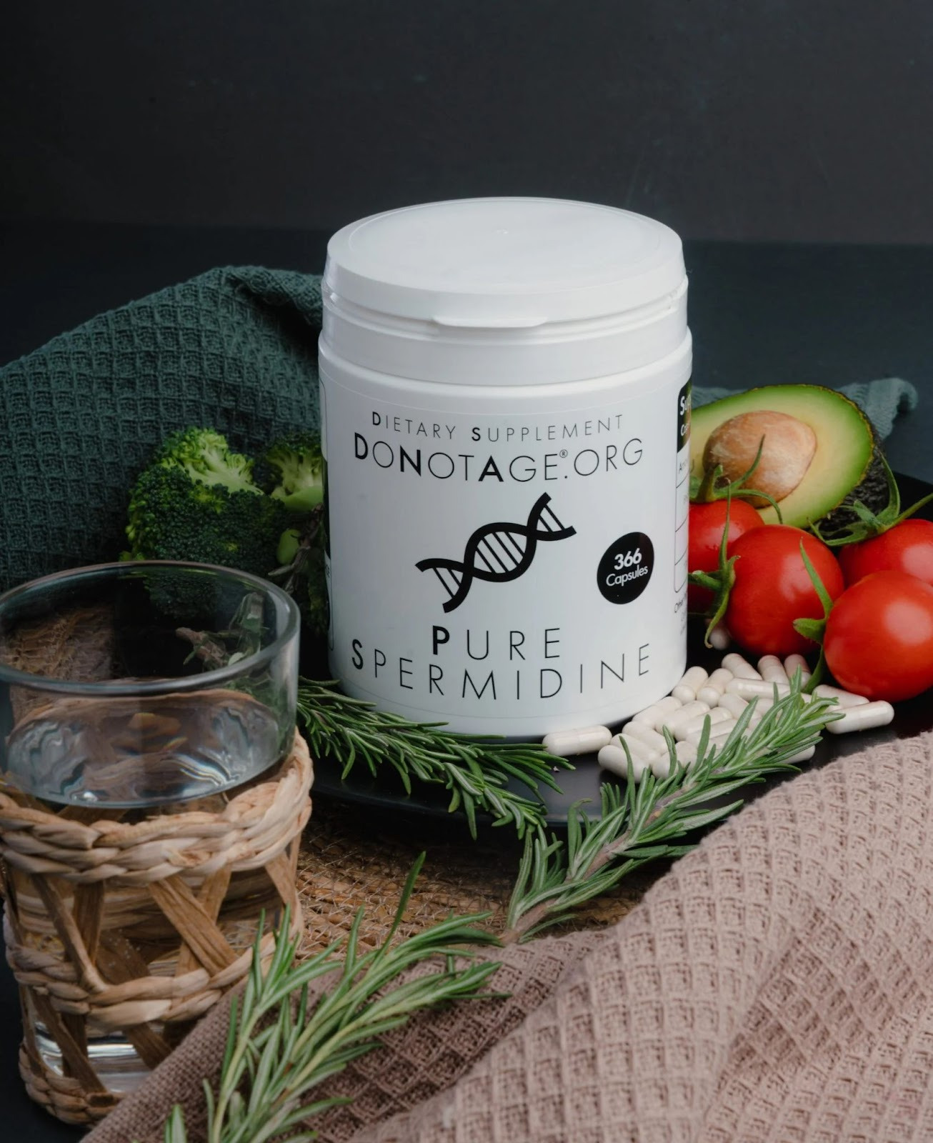 Container of Spermidine supplements around a glass of water, vegetables and capsules.