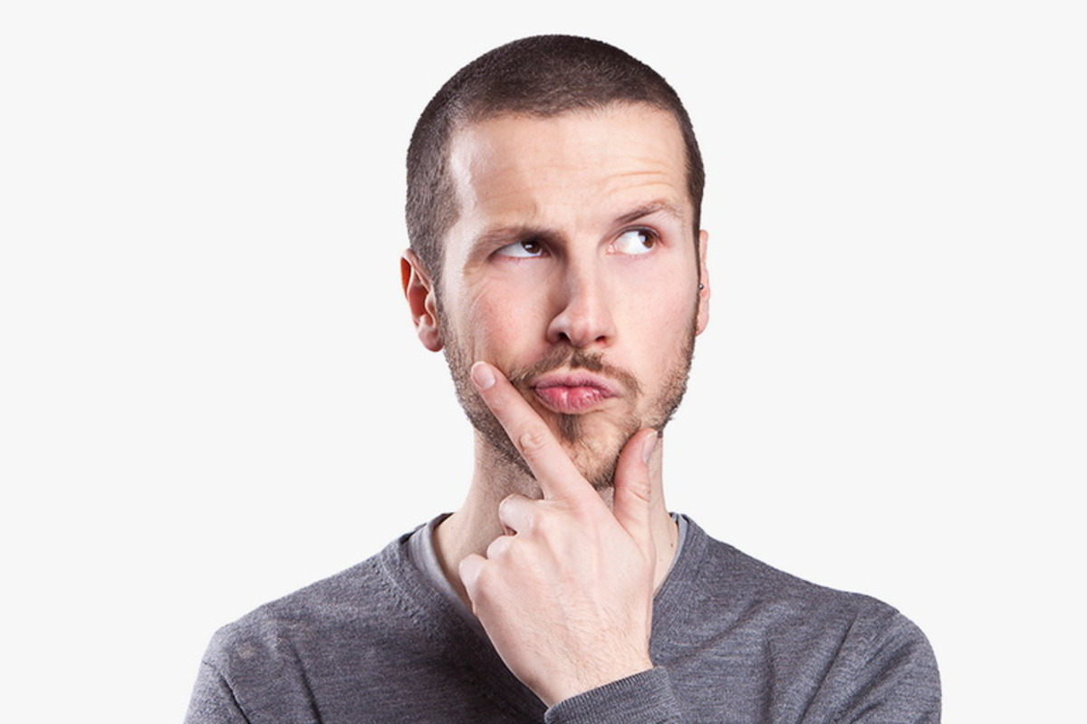 A man poses for the camera, hand on chin, conveying a contemplative expression.