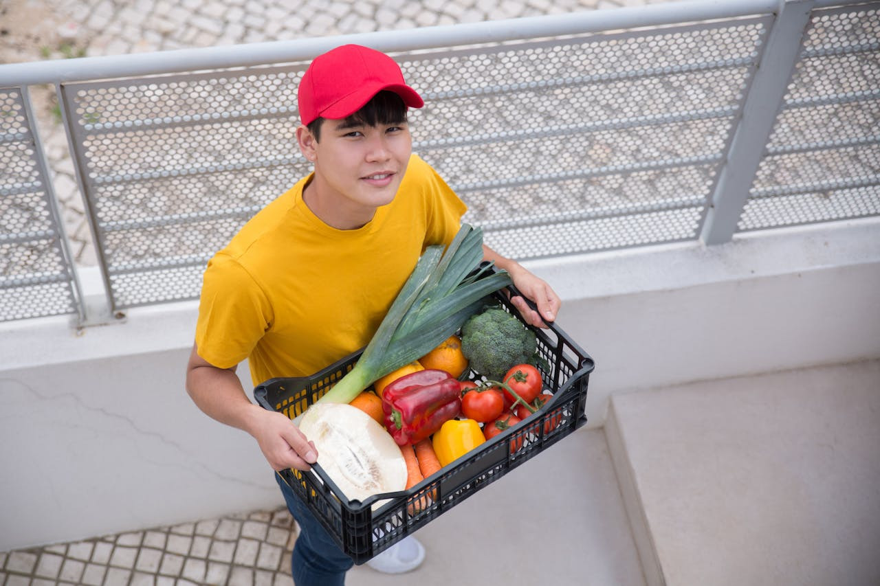 vegetarian man carrying an armload of nutritious vegetables, considering how to incorporate foods that produce collagen into his balanced diet