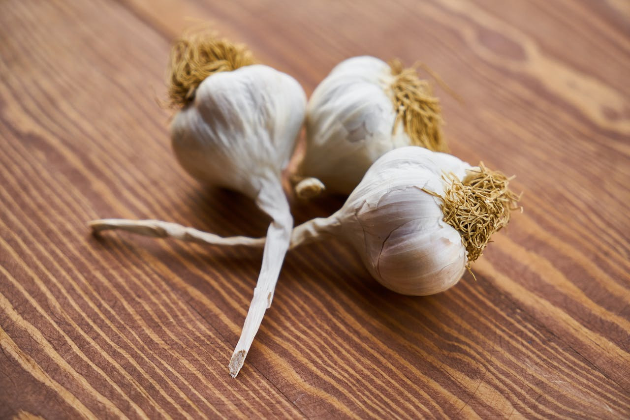 three garlic bulbs on a cutting board