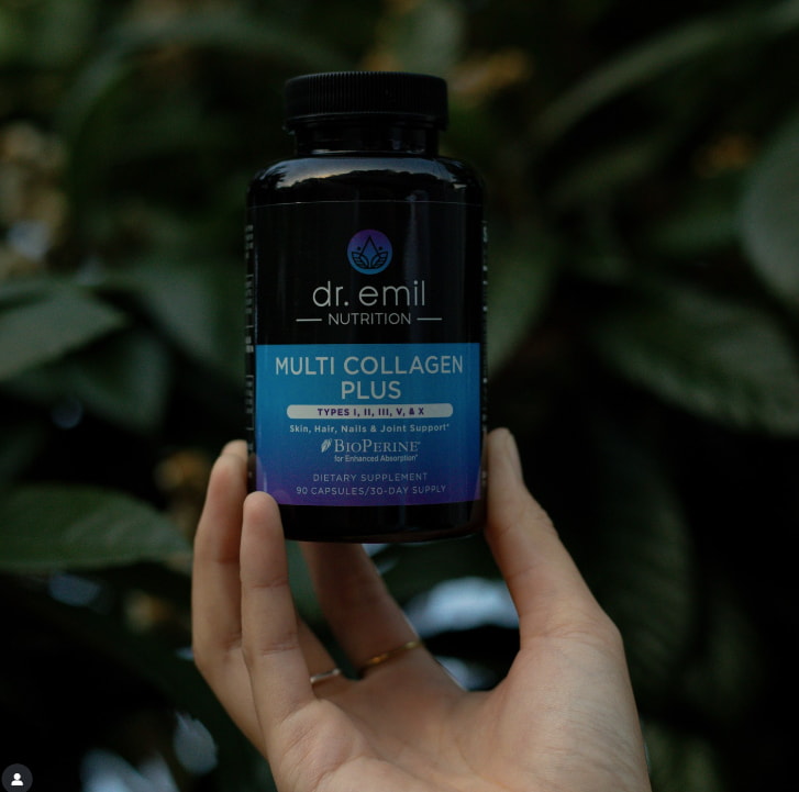 A person holding a bottle of Dr. Emil's multivitamin, showcasing the label and the product's vibrant packaging.