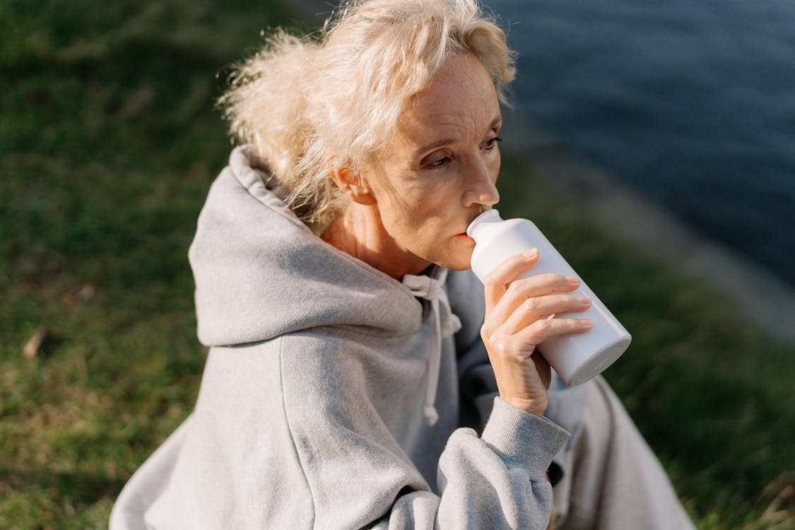 healthy, happy woman making good wellness choices by drinking 