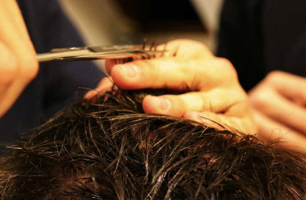 man with thick hair getting a hair cut