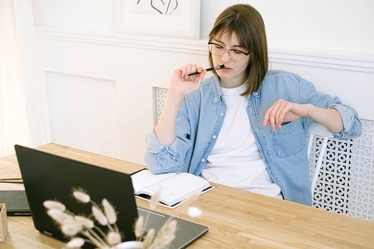 writer sitting in front of a laptop, thinking