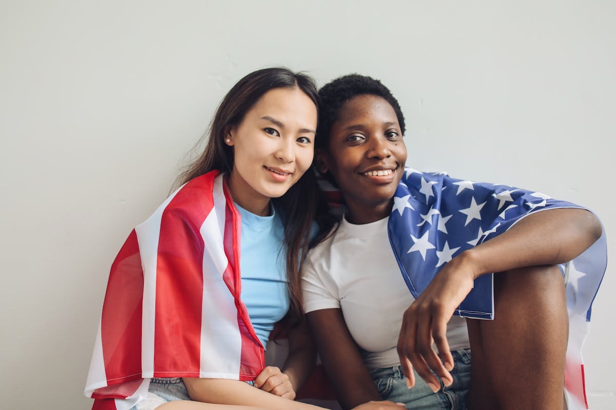 two smiling women wrapped in a flag